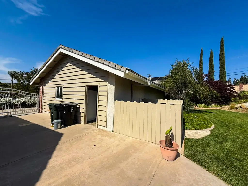 Yorba Linda house exterior with repaired siding and fence during the renovation process.