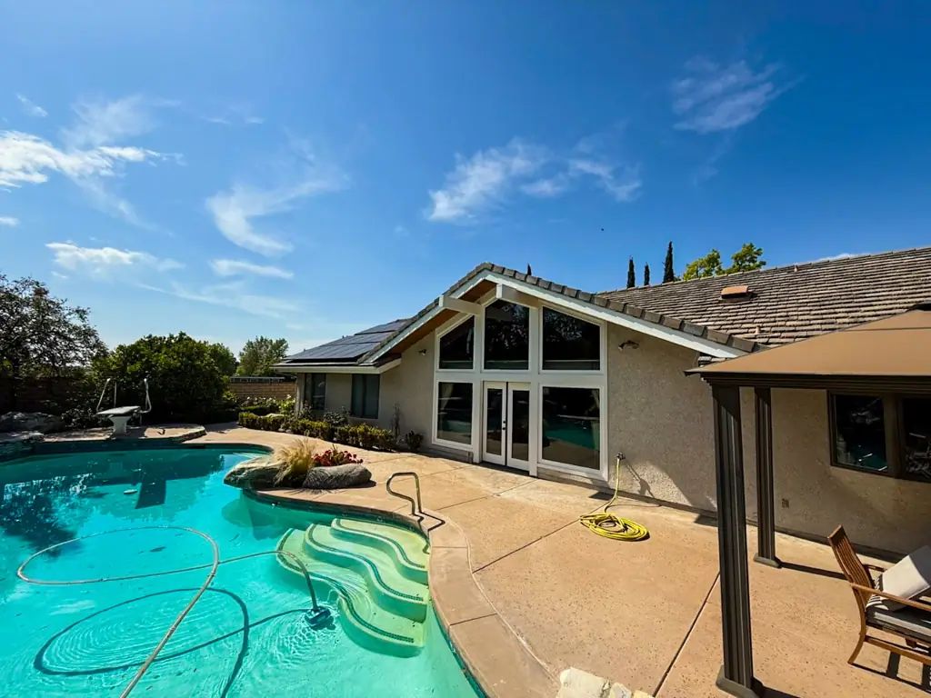 Beautifully painted Yorba Linda home exterior with large windows, viewed from the pool area, after Dream Painting's work.