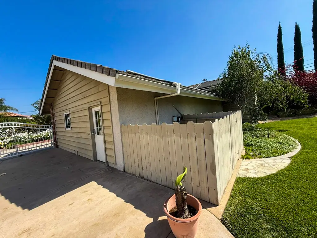 Side view of Yorba Linda house exterior and fence before professional painting and restoration.