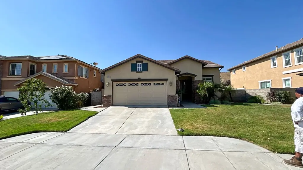 Freshly painted Highland CA home exterior with modern neutral stucco and elegant dark green shutters by Dream Painting contractors