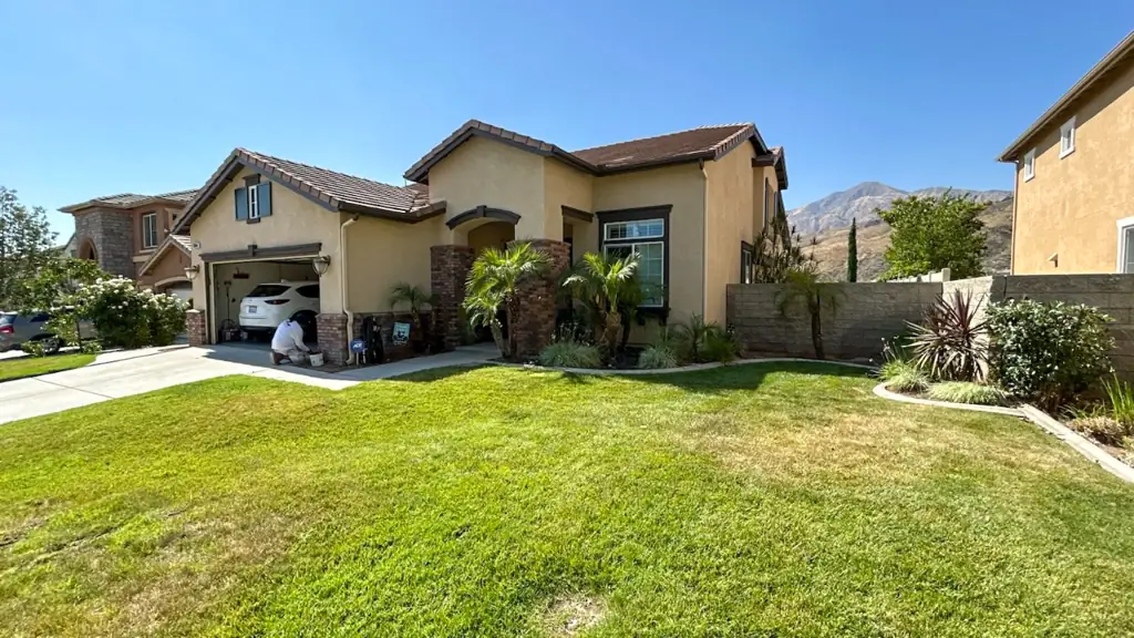 Side angle view of Highland California home before painting showing weathered stucco walls and aging exterior paint