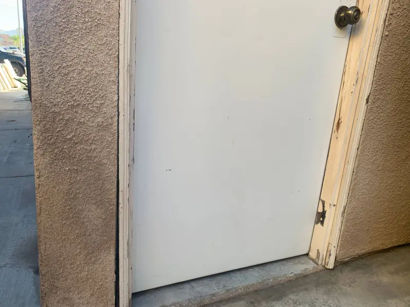 Before painting photo showing weathered door trim, faded paint, and surface preparation needs for exterior painting project in Riverside CA
