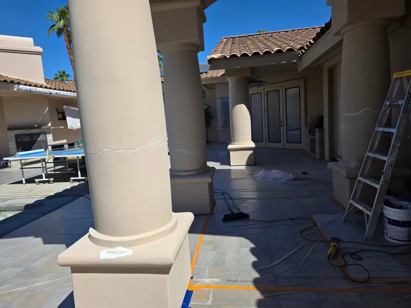 Visible stucco cracks being repaired on exterior columns during painting preparation at a luxury residence in Indian Wells, CA 92210.